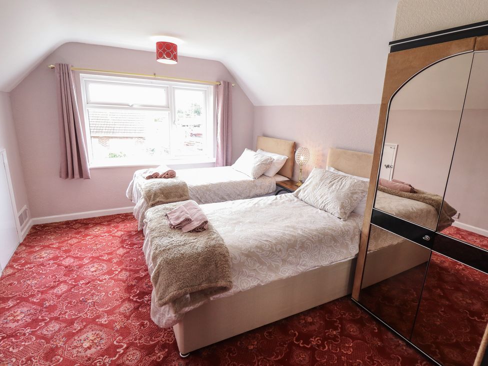 A bedroom with two beds and a window at Sandringham in Withernsea