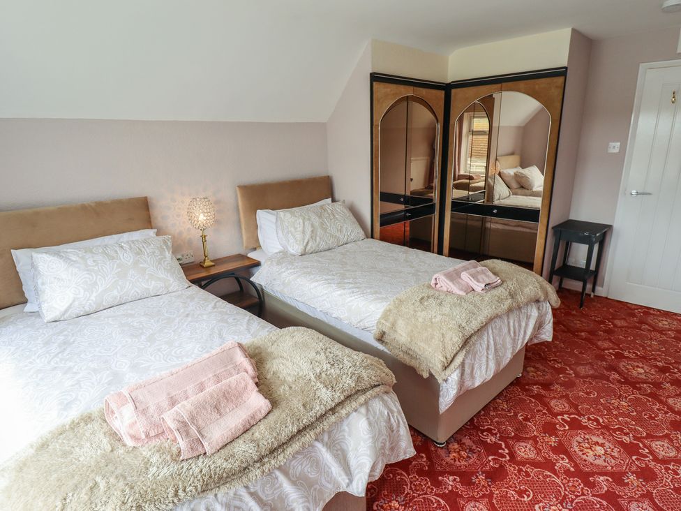 A bedroom with twin beds and a wardrobe at Sandringham in Withernsea