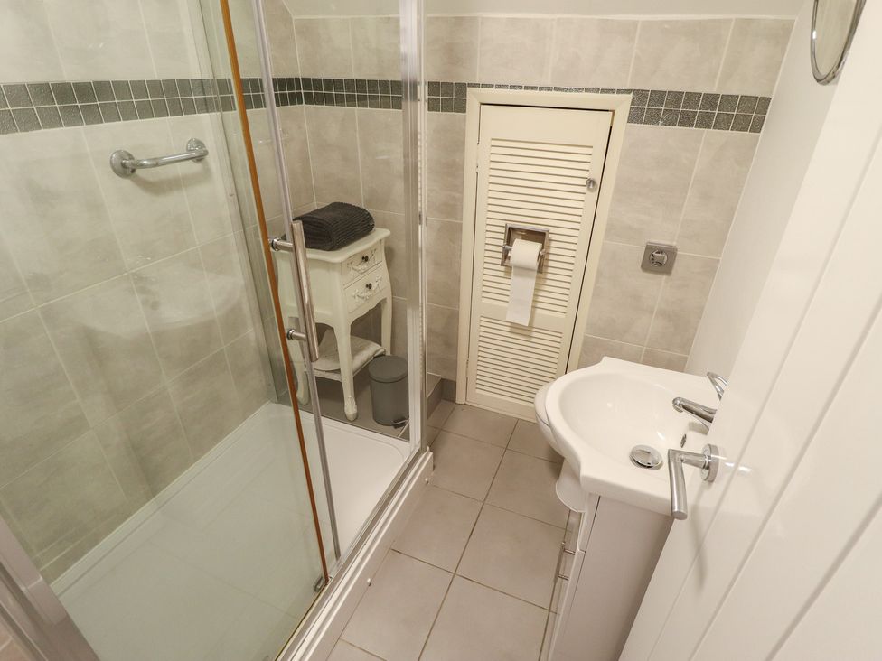 A bathroom with a shower, toilet, and sink at Sandringham in Withernsea