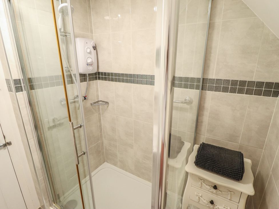 A shower with tiles and a towel in the bathroom at Sandringham in Withernsea