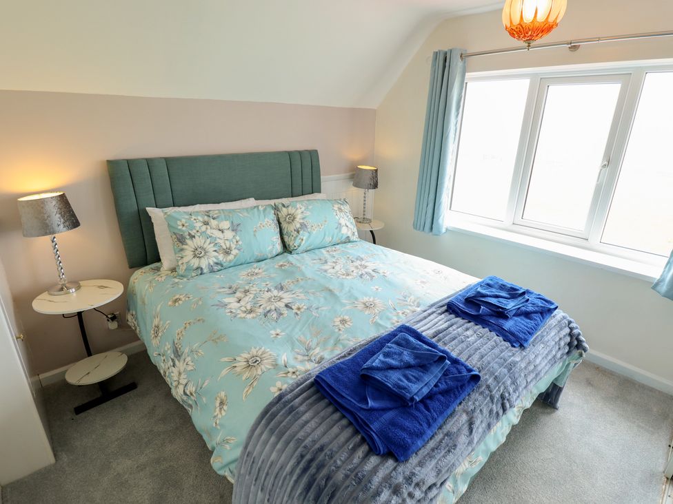 A bedroom with a bed and nightstand at Sandringham in Withernsea