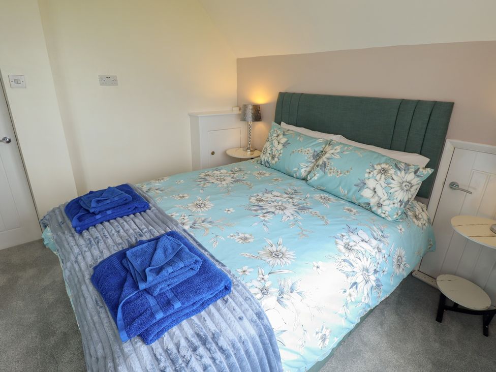 A bedroom with a bed and bedside table at Sandringham in Withernsea