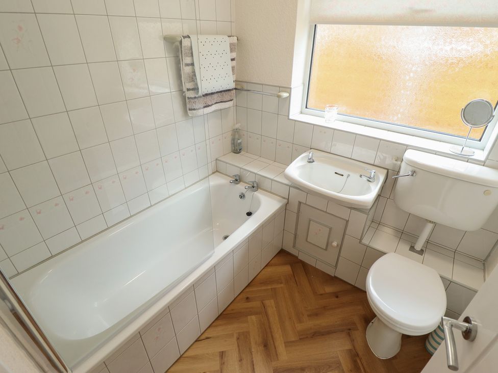A bathroom with a bathtub, toilet, and sink at Sandringham in Withernsea