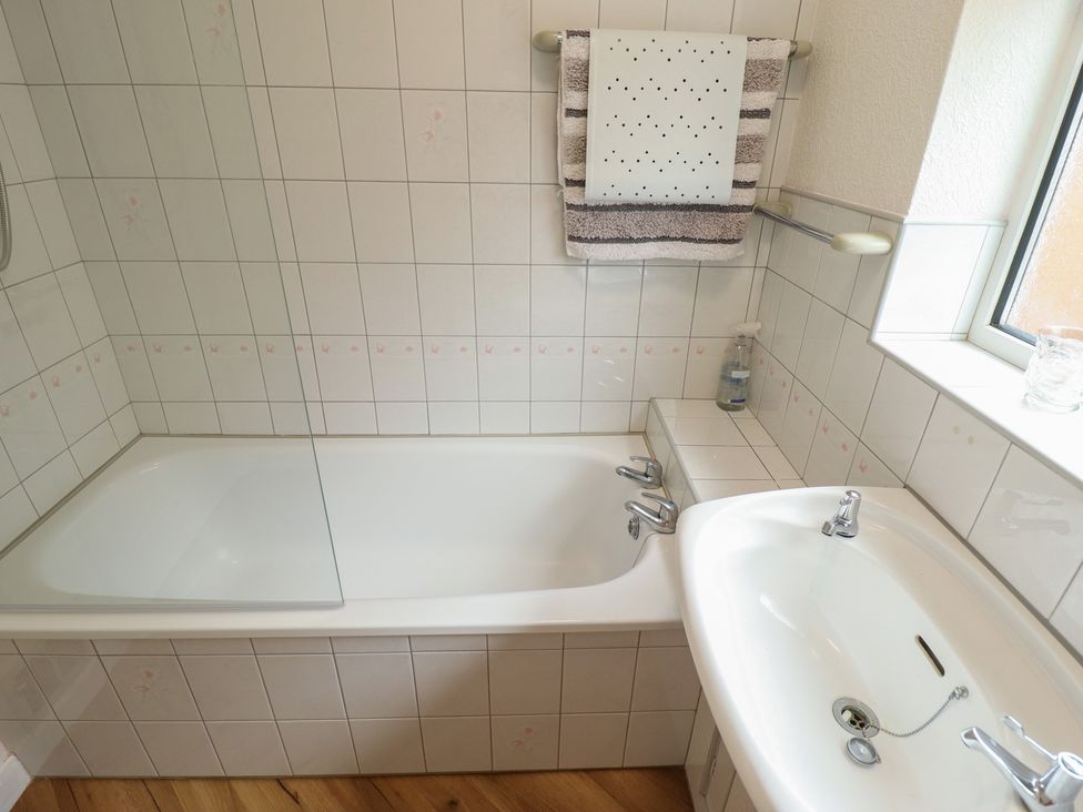 A bathroom with a bathtub and sink at Sandringham in Withernsea