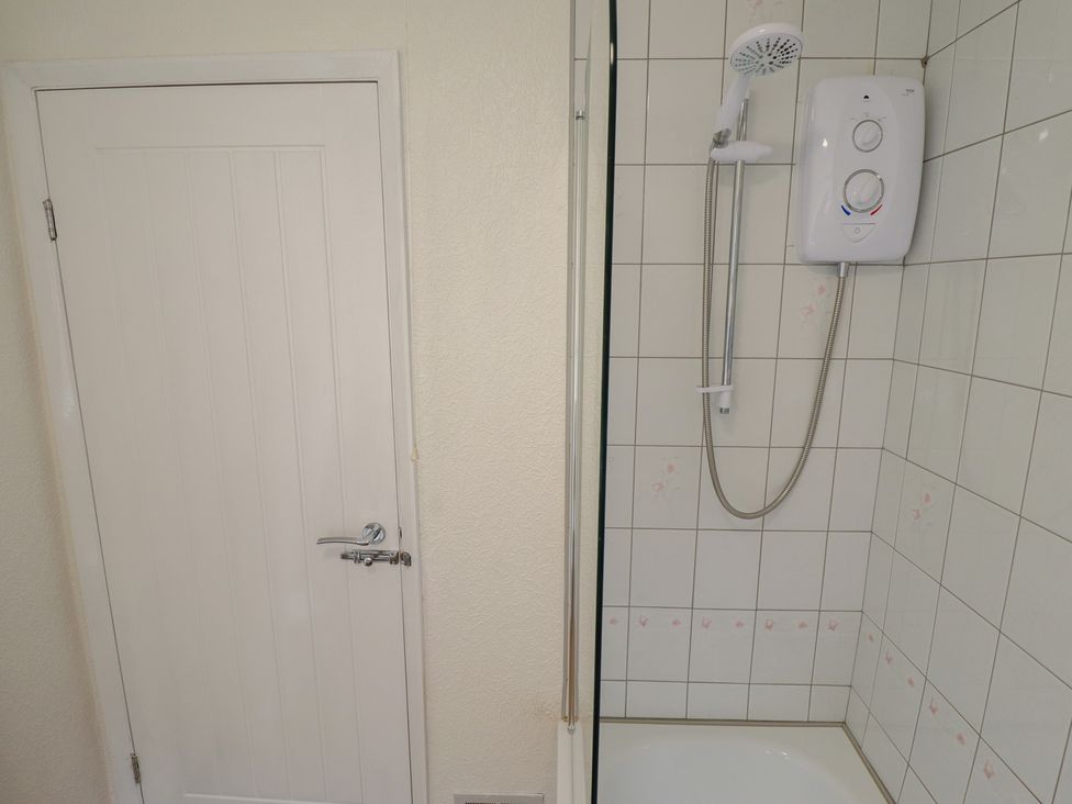 A bathroom with a shower and a door at Sandringham in Withernsea