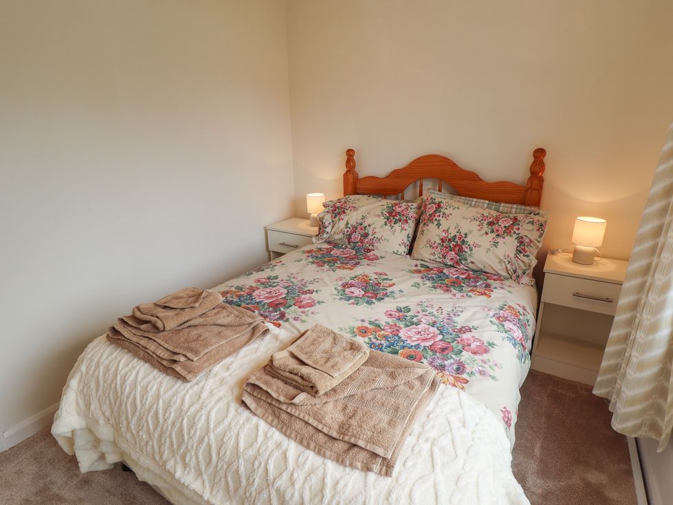 A bedroom with a bed and towels at Sandringham in Withernsea