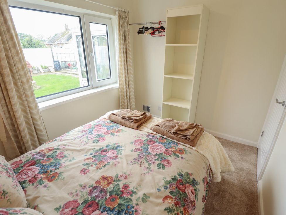 A bedroom with a bed and a bookshelf at Sandringham in Withernsea