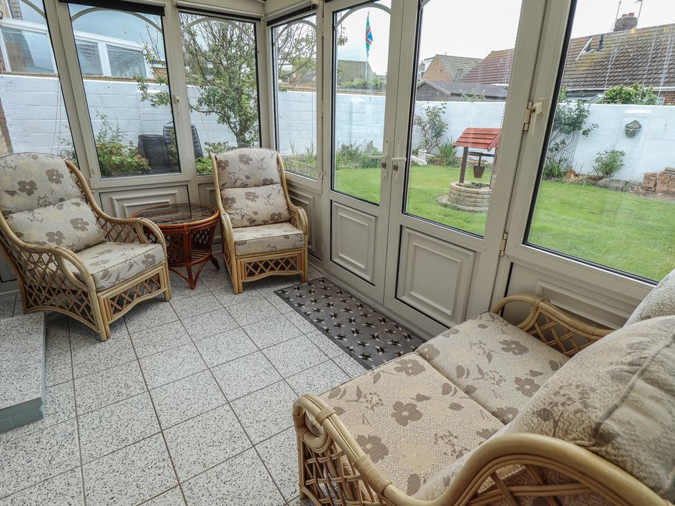 A conservatory with seating and plants at Sandringham in Withernsea