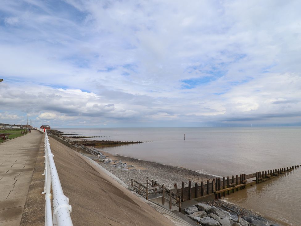 A seaside promenade with wooden groynes and a rocky shore at Sandringham in Withernsea