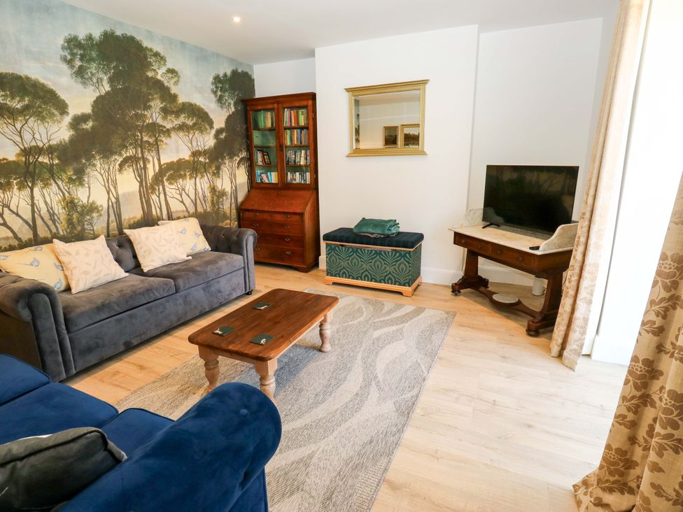 A living room with a sofa, coffee table, and television at Stewards House in Tadcaster