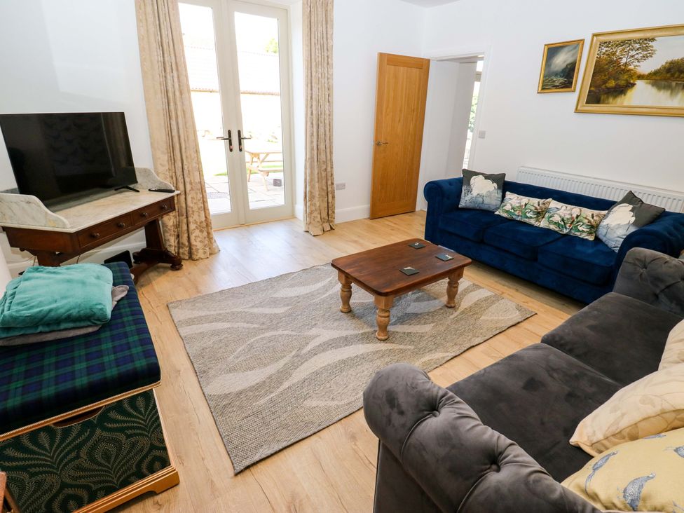 A living room with a television and sofas at Stewards House in Tadcaster