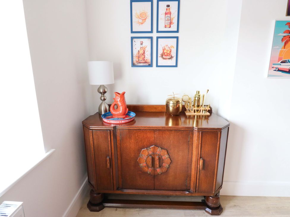A living room with a sideboard and decorative items at Stewards House in Tadcaster