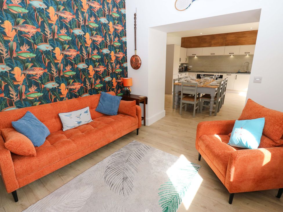 A living room with an orange sofa and armchair at Stewards House in Tadcaster