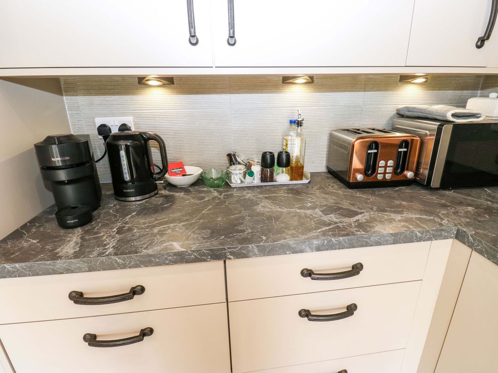 A kitchen countertop with coffee maker kettle toaster and microwave at Stewards House Tadcaster