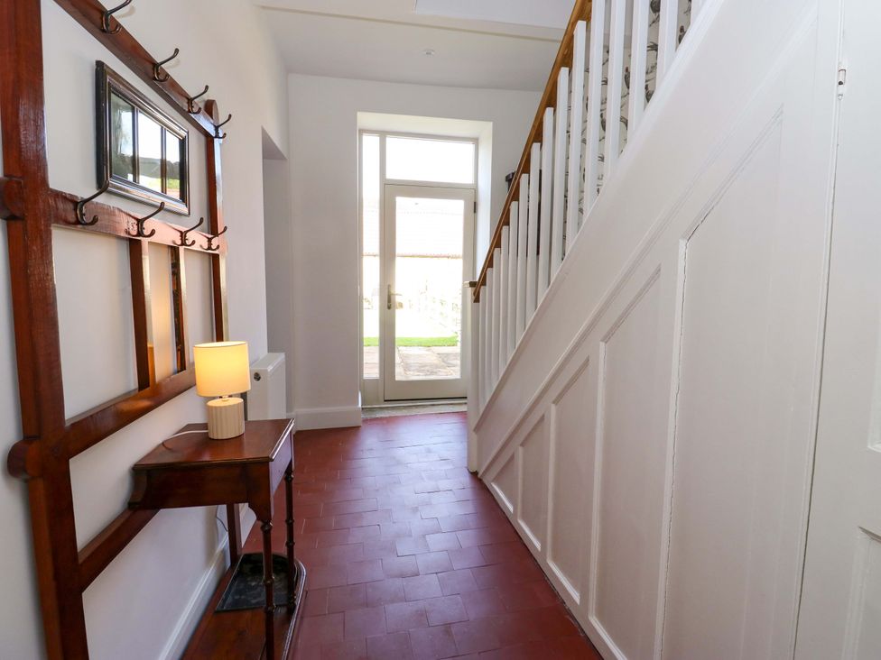 A hallway with a staircase and a table at Stewards House Tadcaster