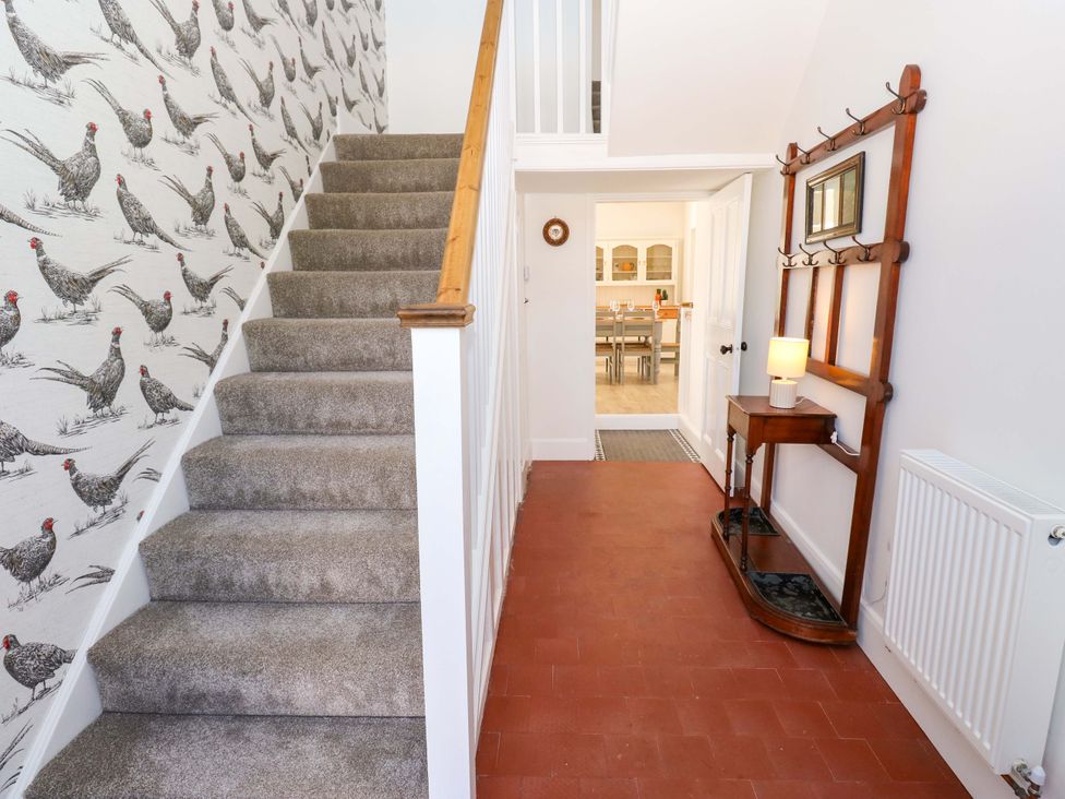 A hallway with a staircase and console table at Stewards House Tadcaster