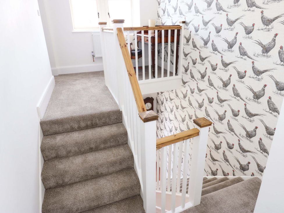 A staircase with a handrail and wallpaper at Stewards House Tadcaster