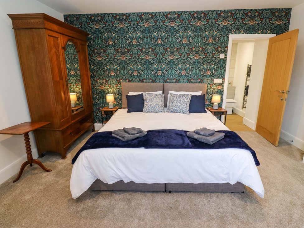 A bedroom with a bed and wardrobe at Stewards House Tadcaster