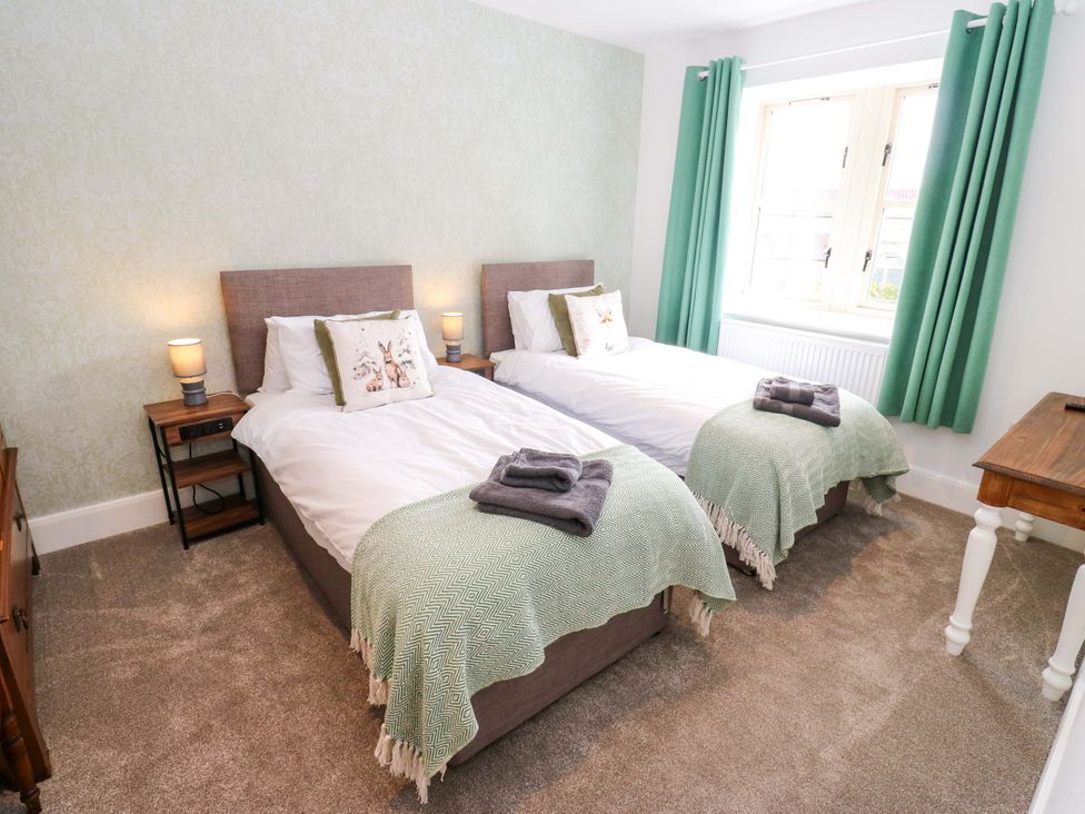 A bedroom with two beds and window at Stewards House Tadcaster
