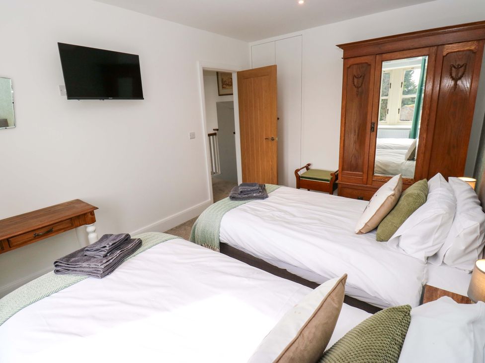 A bedroom with two beds and a wardrobe at Stewards House Tadcaster