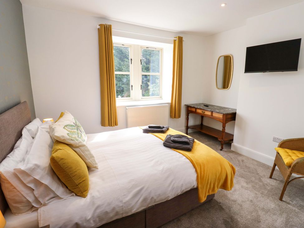 A bedroom with a bed and television at Stewards House Tadcaster