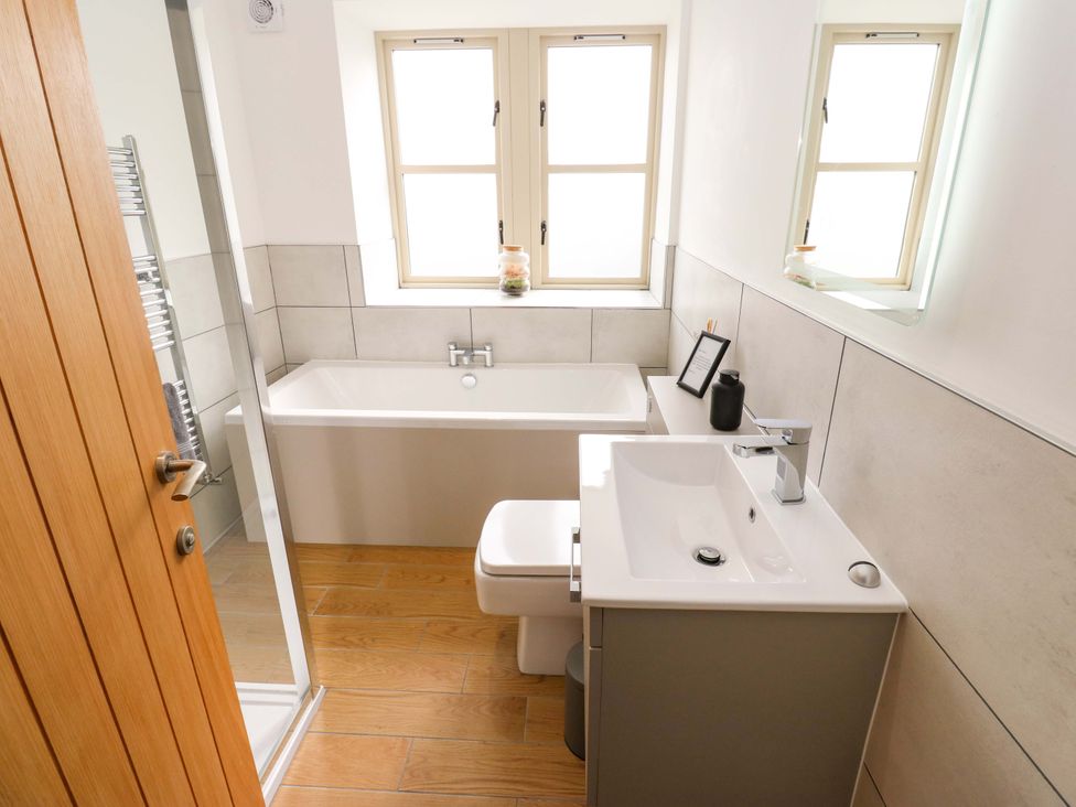 A bathroom with a bath tub, sink, and toilet at Stewards House in Tadcaster