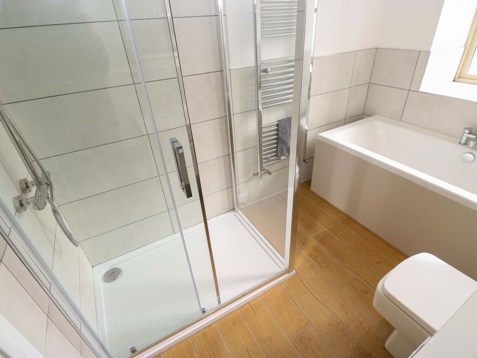 A bathroom with a shower, bathtub, and toilet at Stewards House in Tadcaster