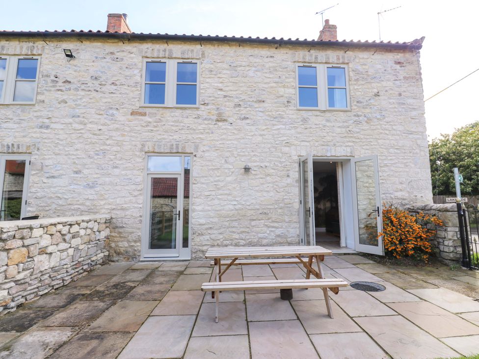 An outdoor area with a stone house and table at Stewards House in Tadcaster