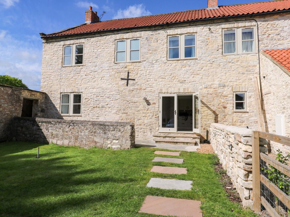 An outdoor view with a stone wall and pathway at Stewards House in Tadcaster