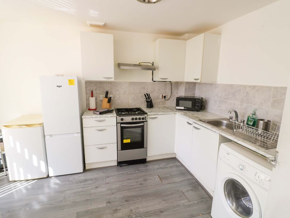 A kitchen with a stove, refrigerator, microwave, and sink at 2 Carpenters Court in Birmingham