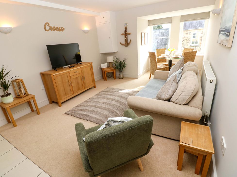 A living room with a sofa and television at 3 Rhodewood House Saundersfoot