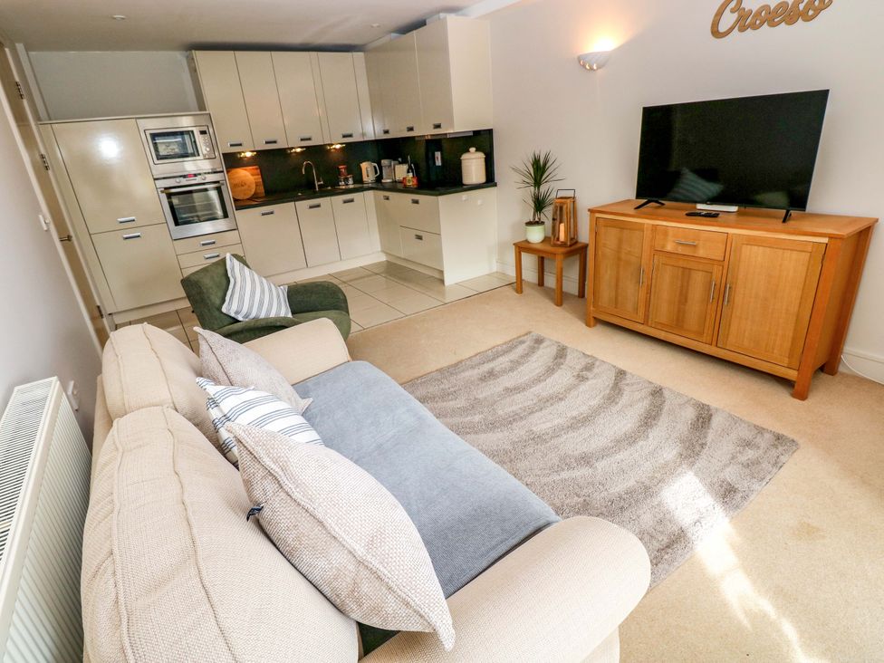 A living room with a sofa and a television at 3 Rhodewood House in Saundersfoot