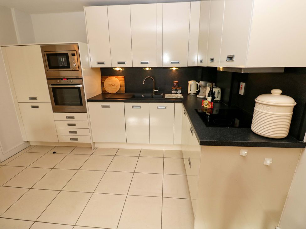 A kitchen with cabinets, oven, sink, and appliances at 3 Rhodewood House in Saundersfoot