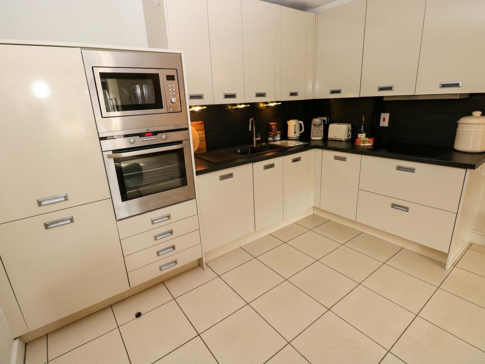 A kitchen with appliances and cabinetry at 3 Rhodewood House Saundersfoot