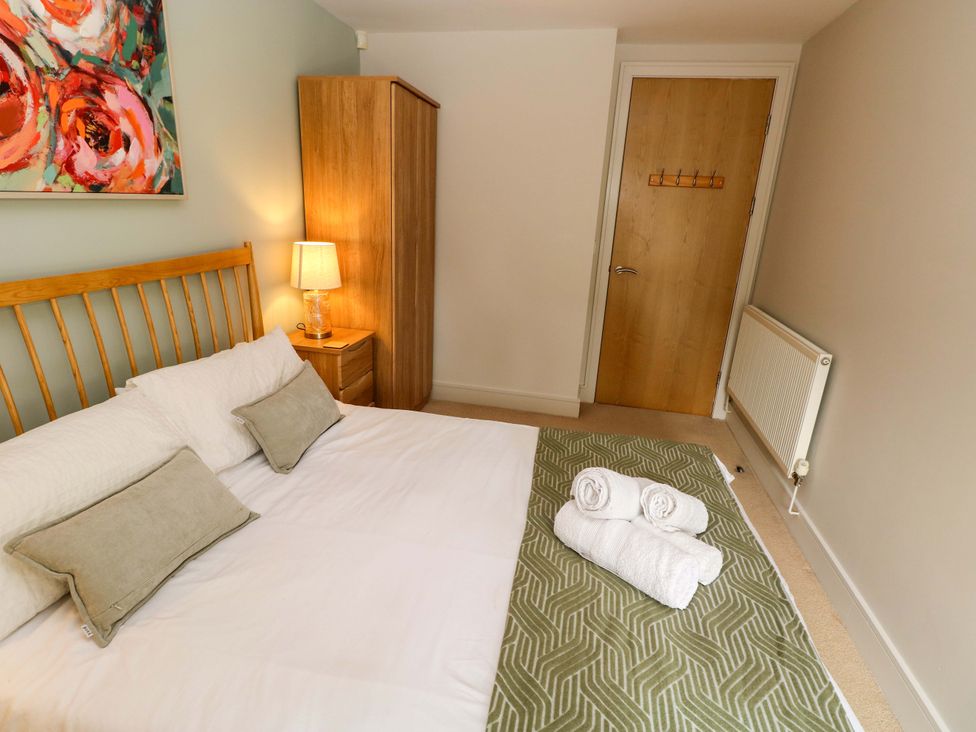 A bedroom with a bed and lamp at 3 Rhodewood House in Saundersfoot