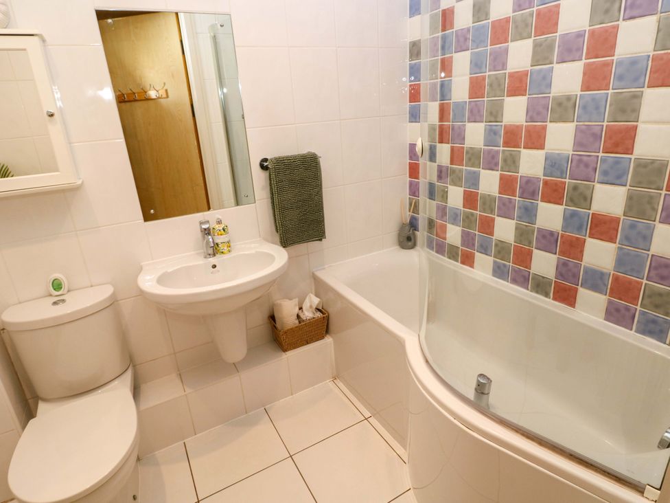 A bathroom with a sink, toilet, and bathtub at 3 Rhodewood House Saundersfoot