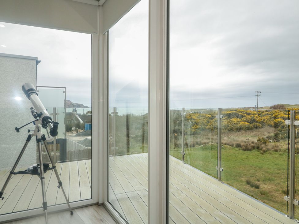 A conservatory with a telescope and views of hills at 2 Ard an Chuain Dunfanaghy