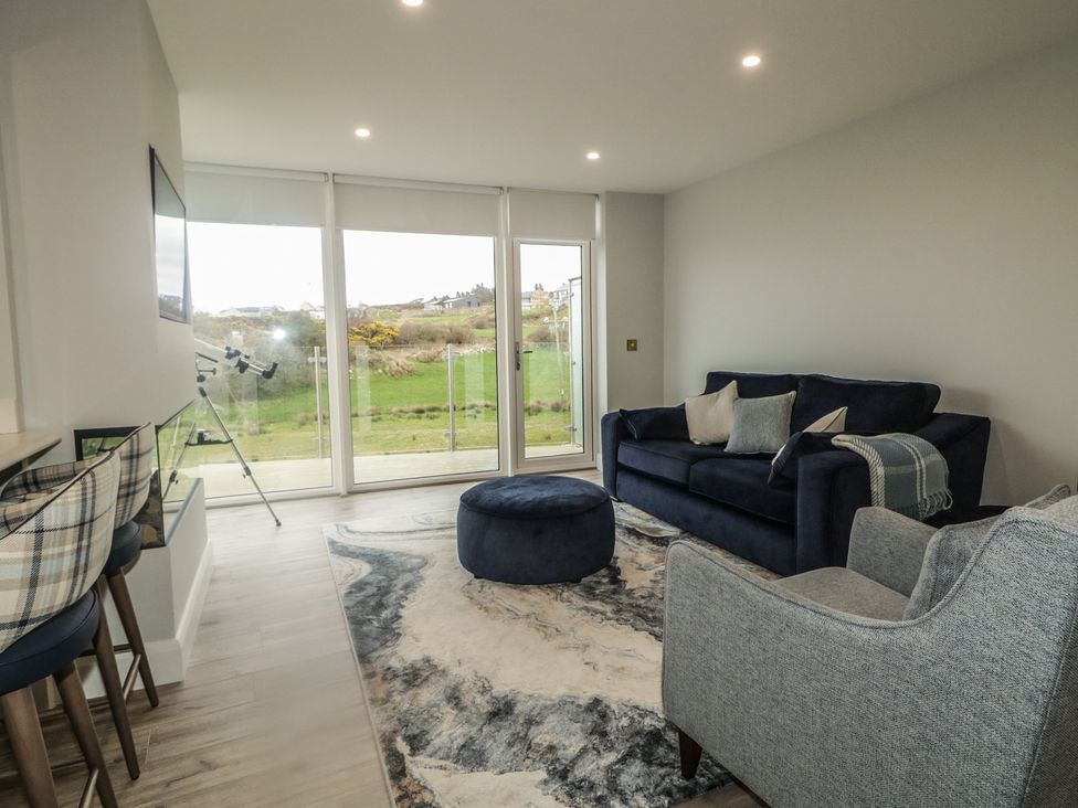 A living room with a sofa and footstool at 2 Ard an Chuain Dunfanaghy