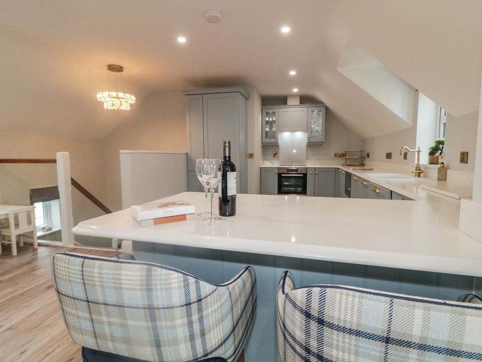 A kitchen with bar stools and a wine bottle at 2 Ard an Chuain Dunfanaghy