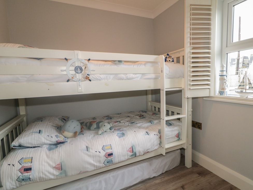 A bunk bed with blue and white bed linen and plush toys at 2 Ard an Chuain Dunfanaghy