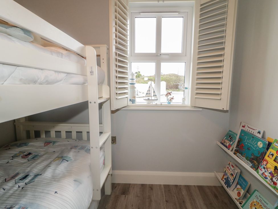 A bedroom with a bunk bed and bookshelf at 2 Ard an Chuain Dunfanaghy