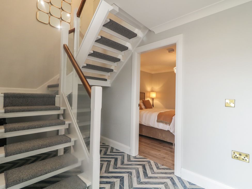 A hallway with a staircase and a doorway to a bedroom at 2 Ard an Chuain Dunfanaghy