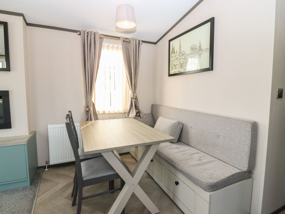 A dining area with a table and bench seating at Plot 243 - Coldingham Bay Leisure Park in Eyemouth