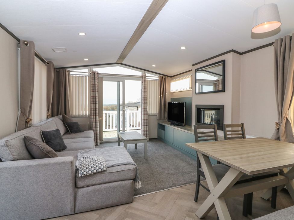 A living room with a sofa and dining table at Plot 243 - Coldingham Bay Leisure Park Eyemouth