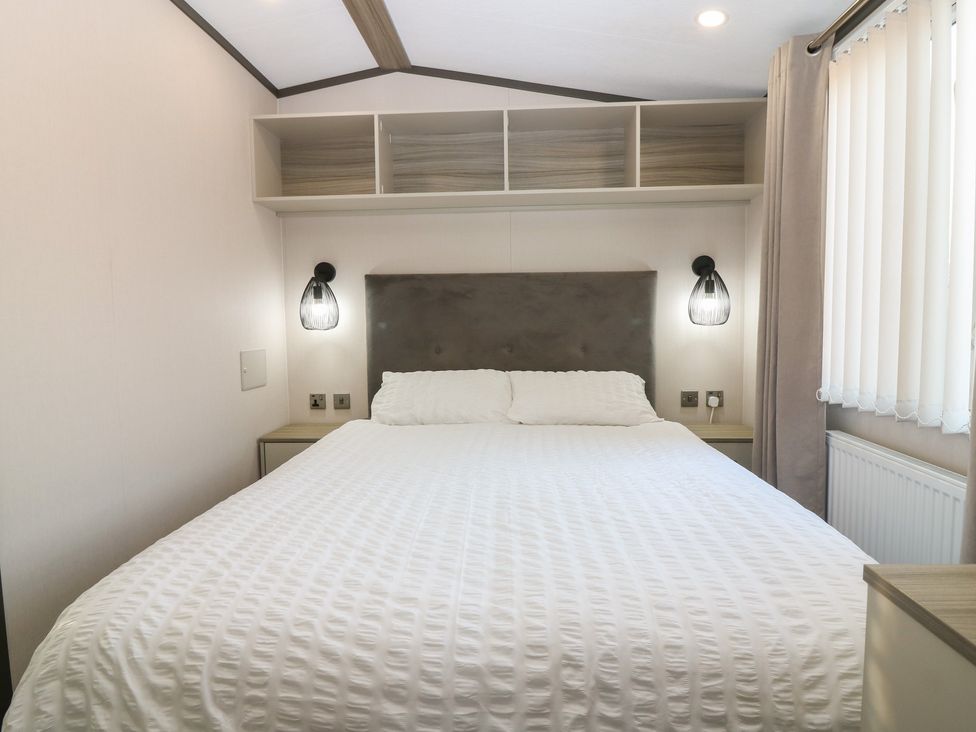 A bedroom with a bed and shelf at Plot 243 - Coldingham Bay Leisure Park in Eyemouth