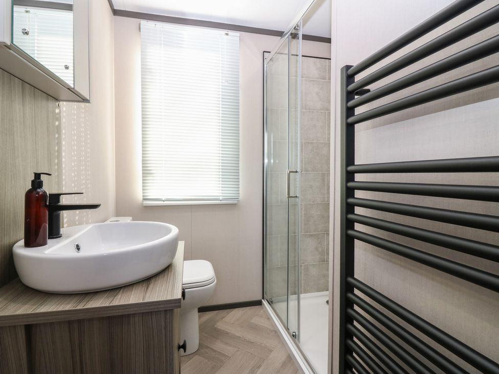 A bathroom with a sink, toilet, shower, and towel radiator at Plot 243 - Coldingham Bay Leisure Park Eyemouth