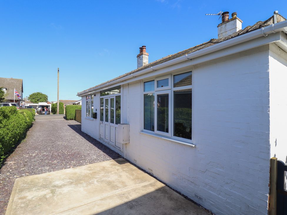 A side view of a house with a pathway and hedge at Sorrento in Mablethorpe
