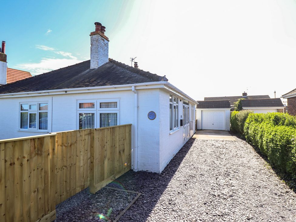 A bungalow with a driveway and fence at Sorrento in Mablethorpe