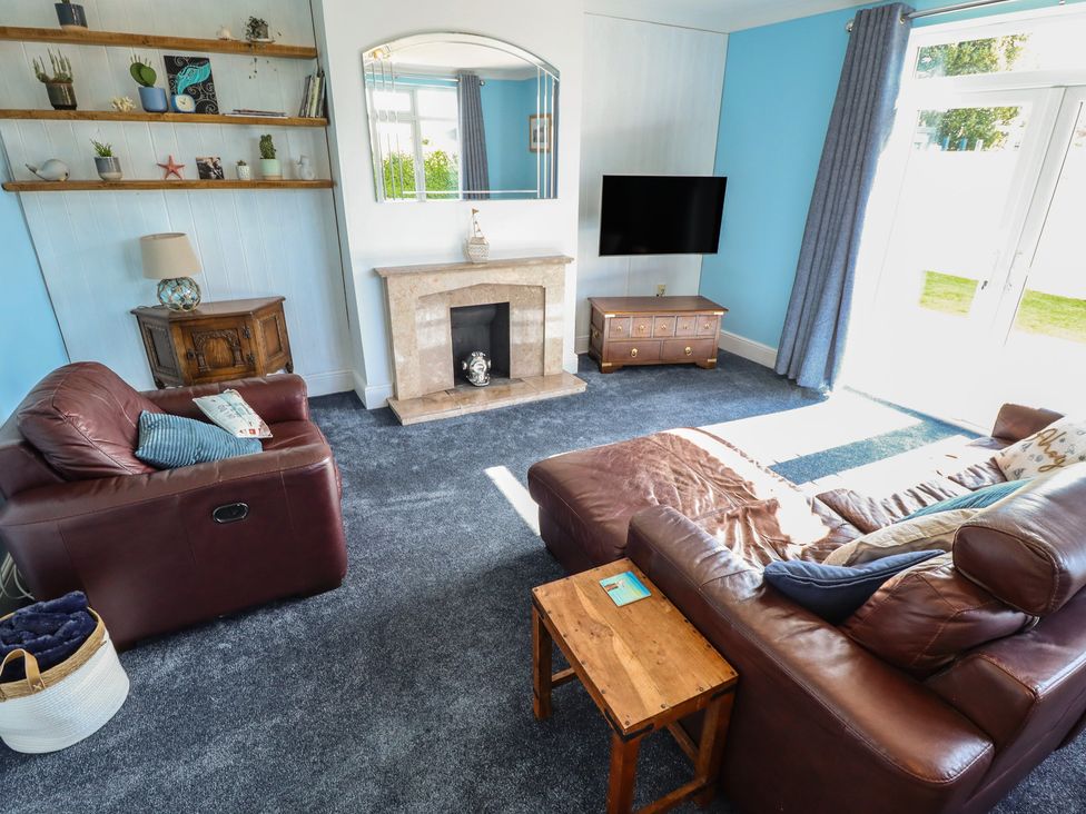 A living room with sofas and a television at Sorrento in Mablethorpe