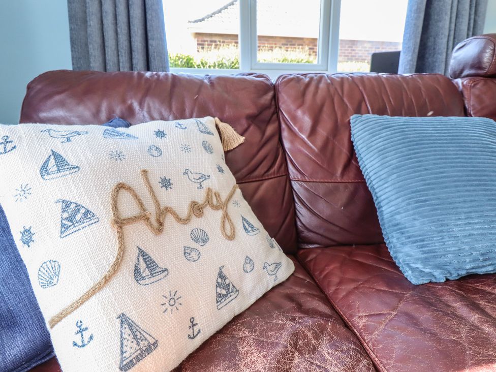 A couch with pillows at Sorrento in Mablethorpe